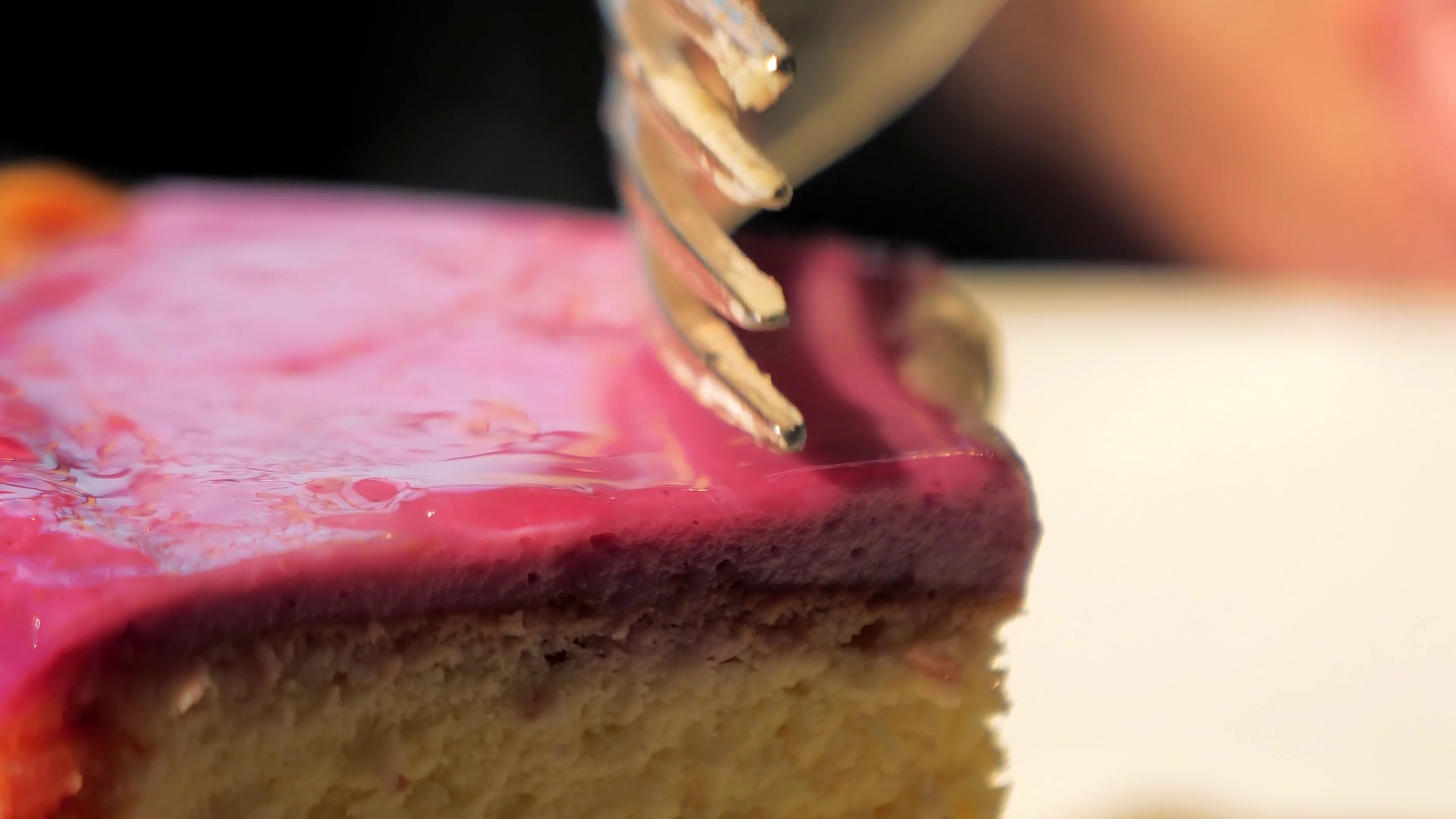 Closeup of breaks off a piece of cheesecake with a fork. Fork on the
