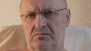 a man with glasses looks at us