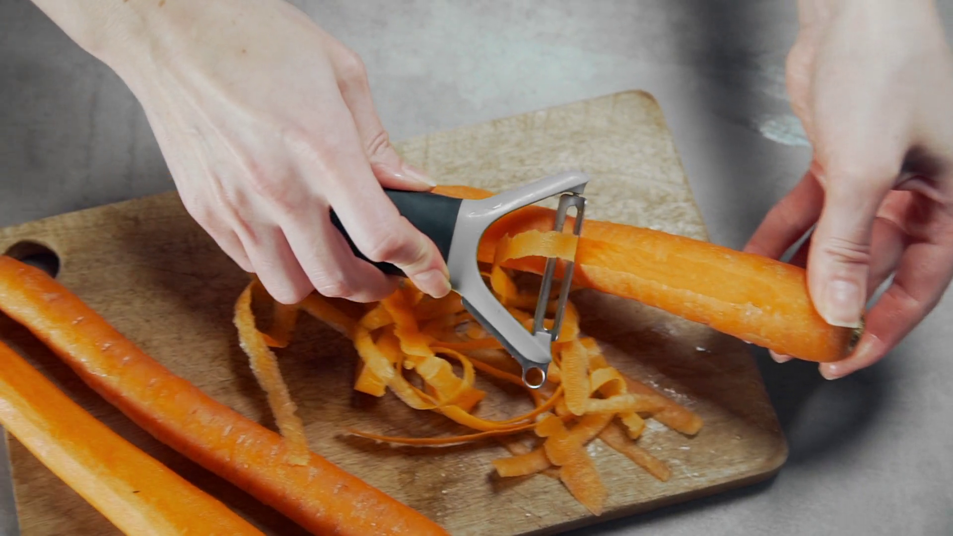 Housewife peels carrot for vegetarian dish, vegetable salad, cooking at home Stock Video Footage - Storyblocks