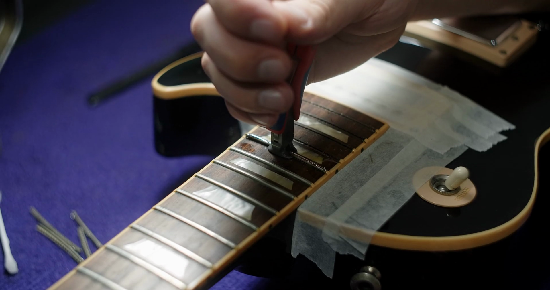 Refretting the guitar, luthier replaces frets on the electric guitar