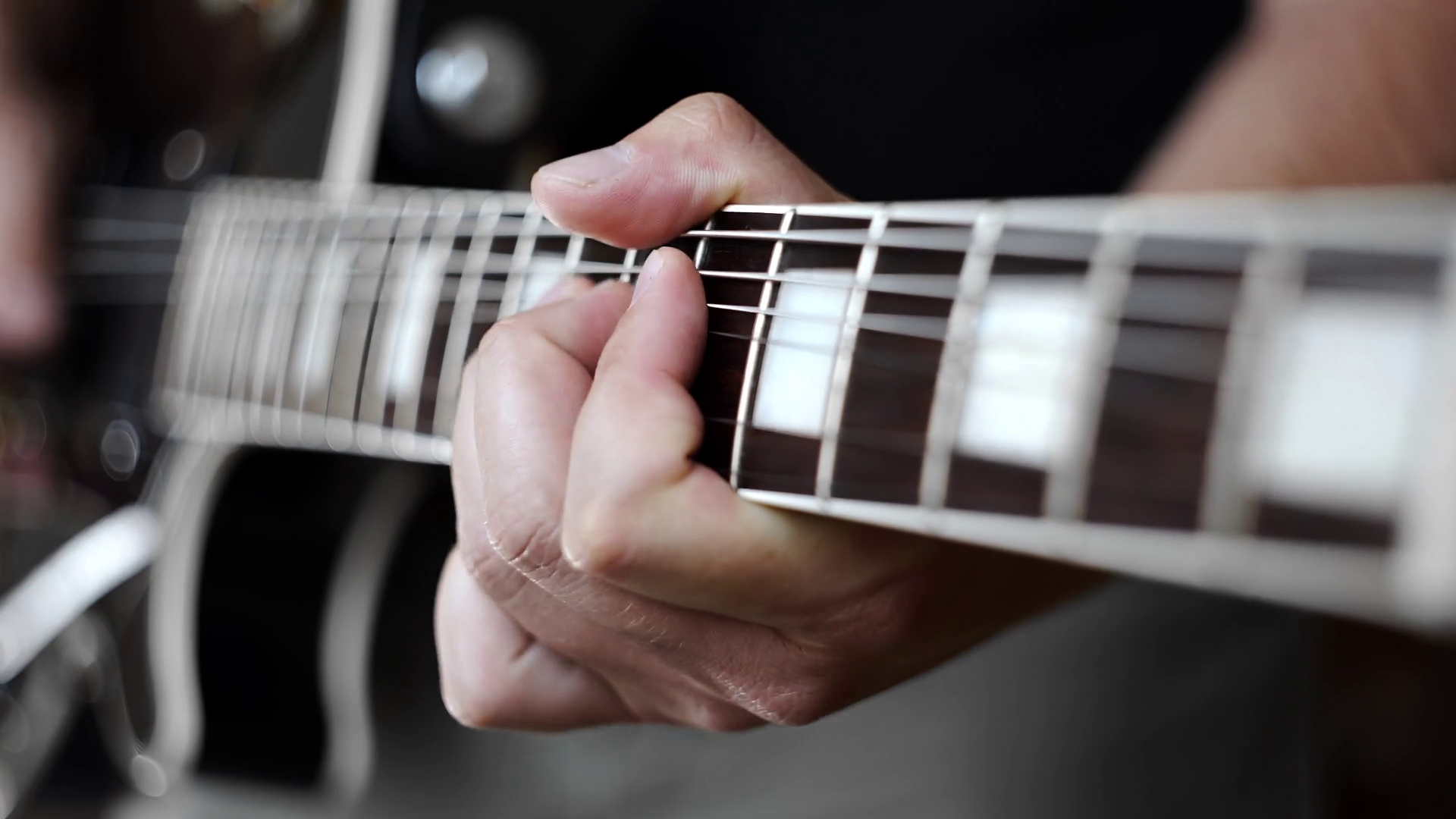 Musician bends the strings on the electric guitar while playing