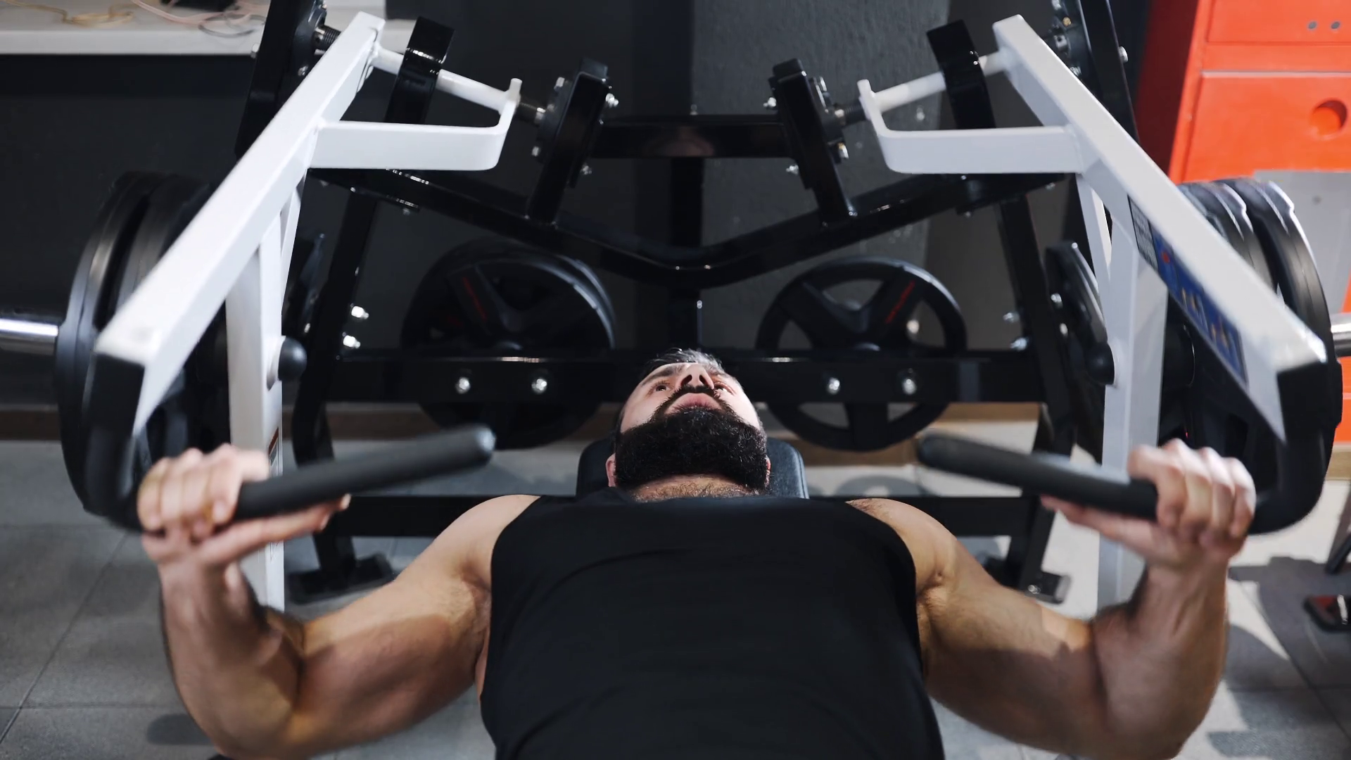 Strong man is pumping muscles at the gym, strength exercises on