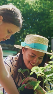 A Heartwarming Moment in Gardening: A Child and an Adult Collaborate on Planting, Nurturing Nature Together in a Lush Green Environment