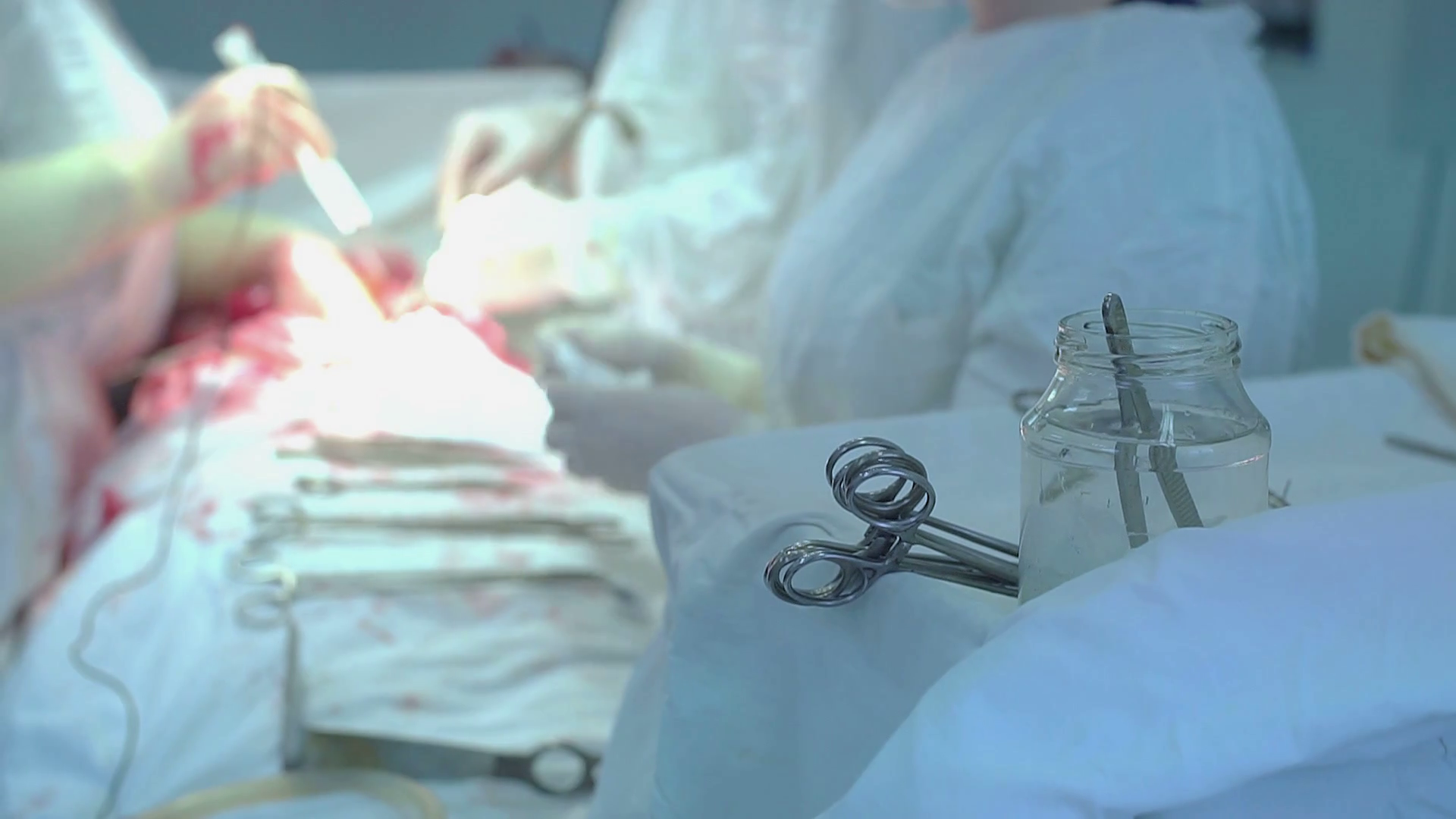 Doctors in hospital wearing protective clothing performing surgery