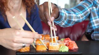 man and woman in a cafe eat sushi and communicate.