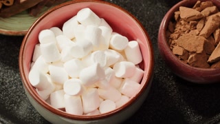 Making cocoa cacao hot chocolate with marshmallows. Man takes a spoon and mixing milk with cocoa powder.