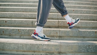 Dancer woman dancing outdoor, legs on stairs close-up. Modern dance choreography. Female professional street dancer showing dance movings. Musical video clip.