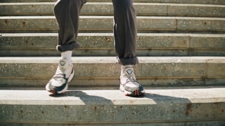 Dancer woman dancing outdoor, legs on stairs close-up. Modern dance choreography. Female professional street dancer showing dance movings. Musical video clip.