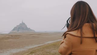Photographer capturing stunning Mont Saint Michel island in foggy weather