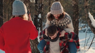 Cheerful happy friends having fun together posing, taking pictures at snowy winter forest, Christmas holiday slow motion