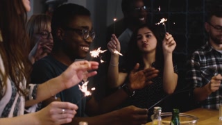 Young people dance with Bengal lights. Slow motion. Birthday celebration house party. Joyful emotion.