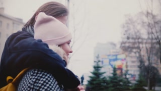 Slow motion joyful couple walking and embracing in snowy winter scenery.