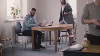Young boss helps male employee in modern office