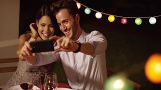 Young couple taking a selfie at a vibrant party