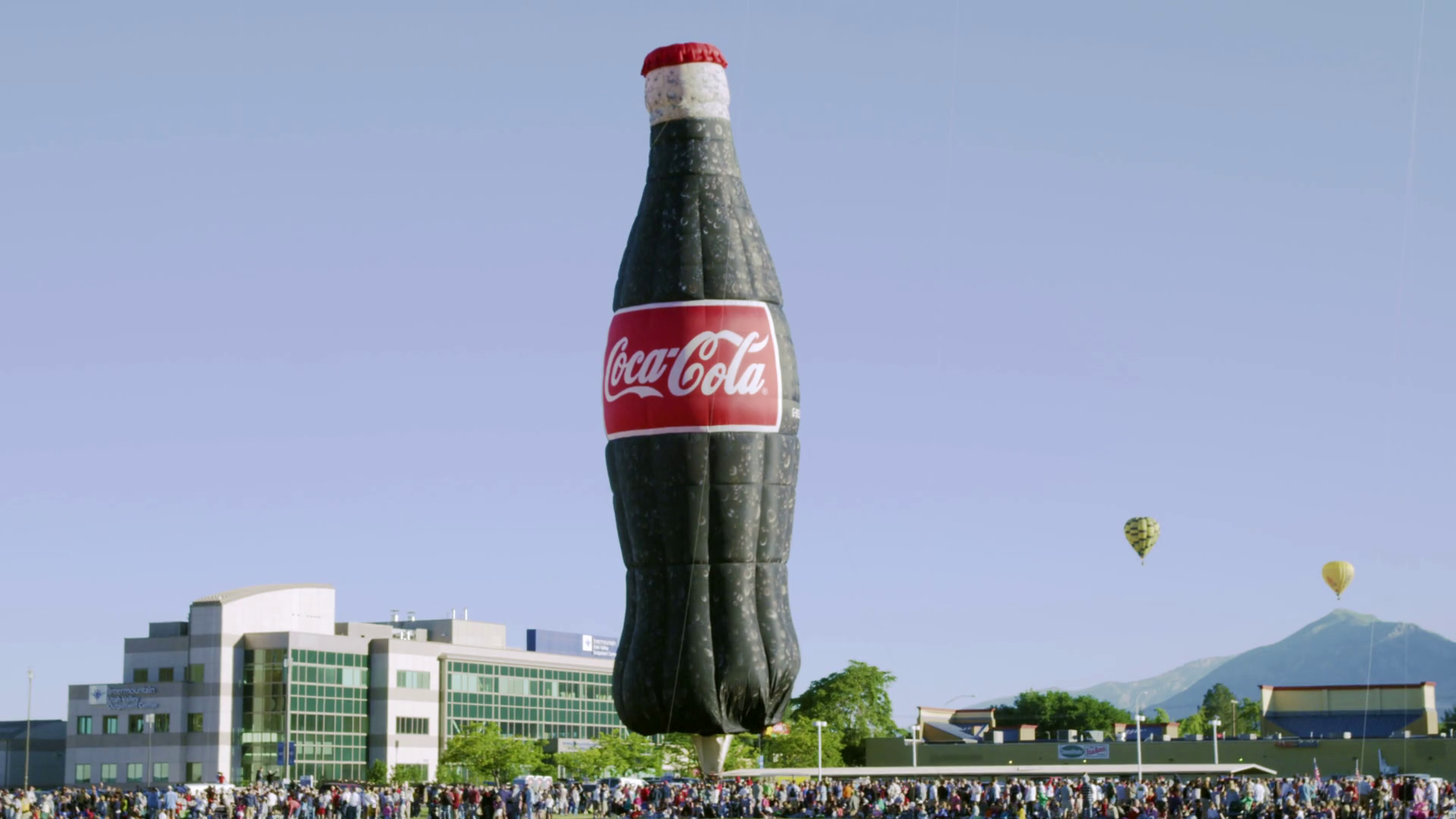 Giant Inflatable Coca Cola Bottle and Hot Air Balloons Stock Video