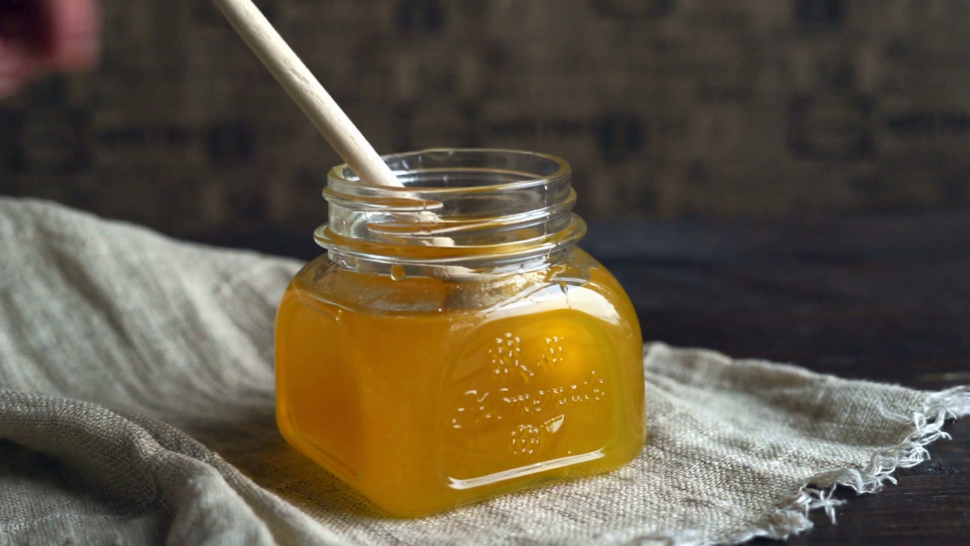 Honey dripping in bottle. Honey flowing from dripper. Honey pouring in