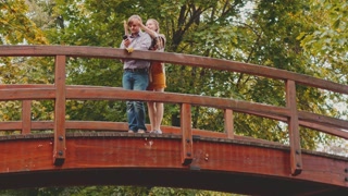 Couple's Romantic Meeting on a Scenic Bridge Outdoors. 4K Ultra HD. Love Concept with Kissing.