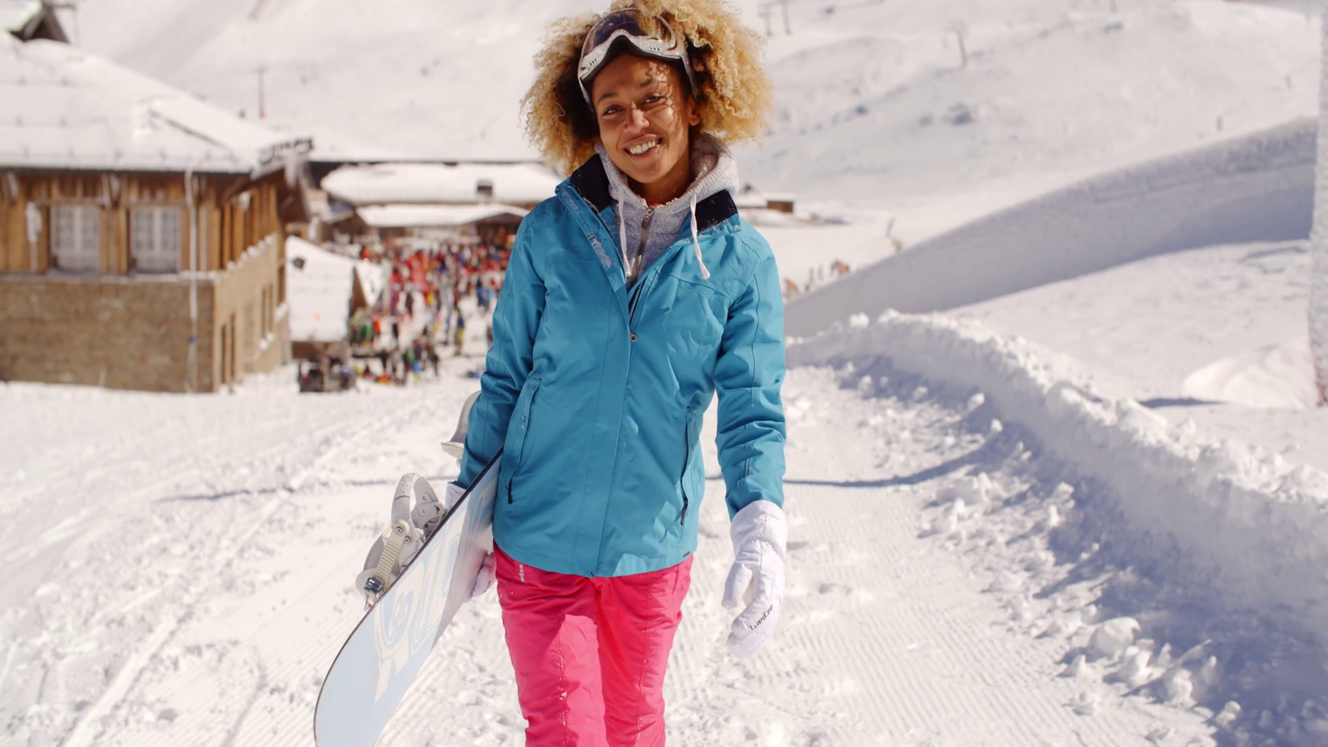 Smiling pretty young woman carrying a snowboard Stock Video Footage 00