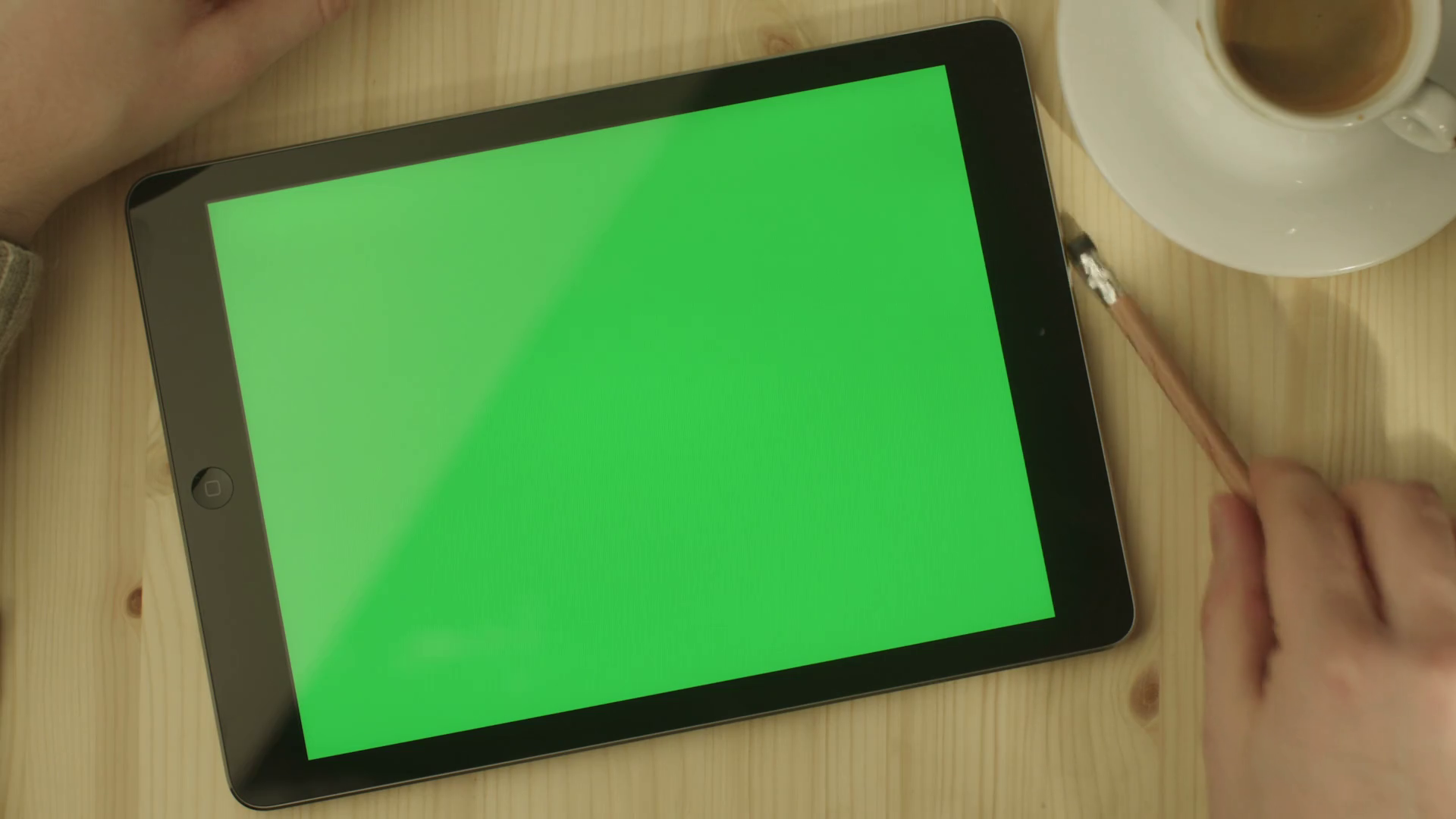 Tablet with Green Screen Laying on a Wooden Table in Landscape Mode