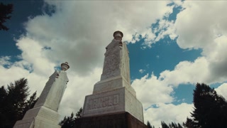 4K UHD Timelapse Shot Looking Up at Gravestone Against Blue Sky