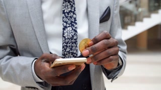 Afroamerican Businessman with bitcoin and mobile phone in Modern Office.