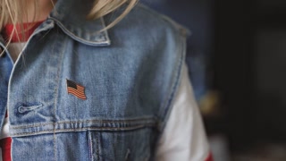 American woman proudly attaches North American flag and state patches to her jacket