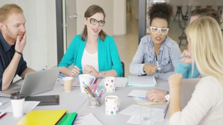 Diverse team discussing graphics and statistics at table
