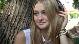 Joyful Girl Enjoying Music with Headphones in the Park