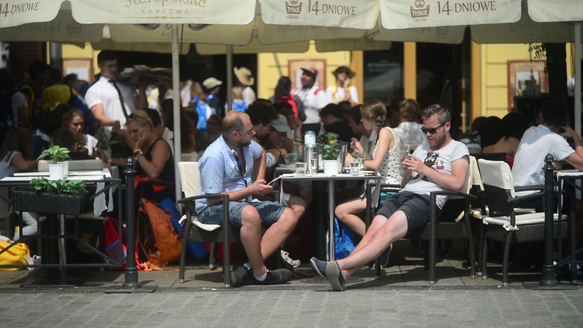 Krakow Market Square, people sitting at street cafe table eating