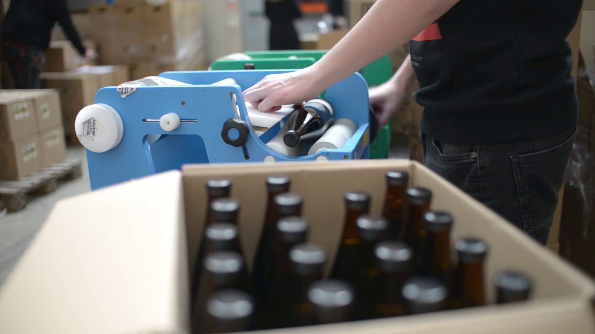 Making Craft Beer in a Brewery sticking a label on bottles in