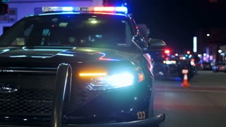 Police vehicles with flashing lights on service at the city street at night. Front view. USA IL Naperville 5 Oct 2025