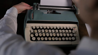 Close-up of vintage typewriter and hands typing, inserting paper, and adjusting the roller. Retro writing process with mechanical keys and