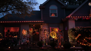 Front yard decorated with Halloween orange lights, pumpkins at night in a suburban. USA Naperville IL 31 Oct 2025