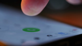 Finger tapping numbers to make a call on iPhone screen. Close up of iOS interface, user navigating smartphone menu. Naperville IL. USA 10