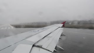 Airplane takes off during the rainy day. Slow motion