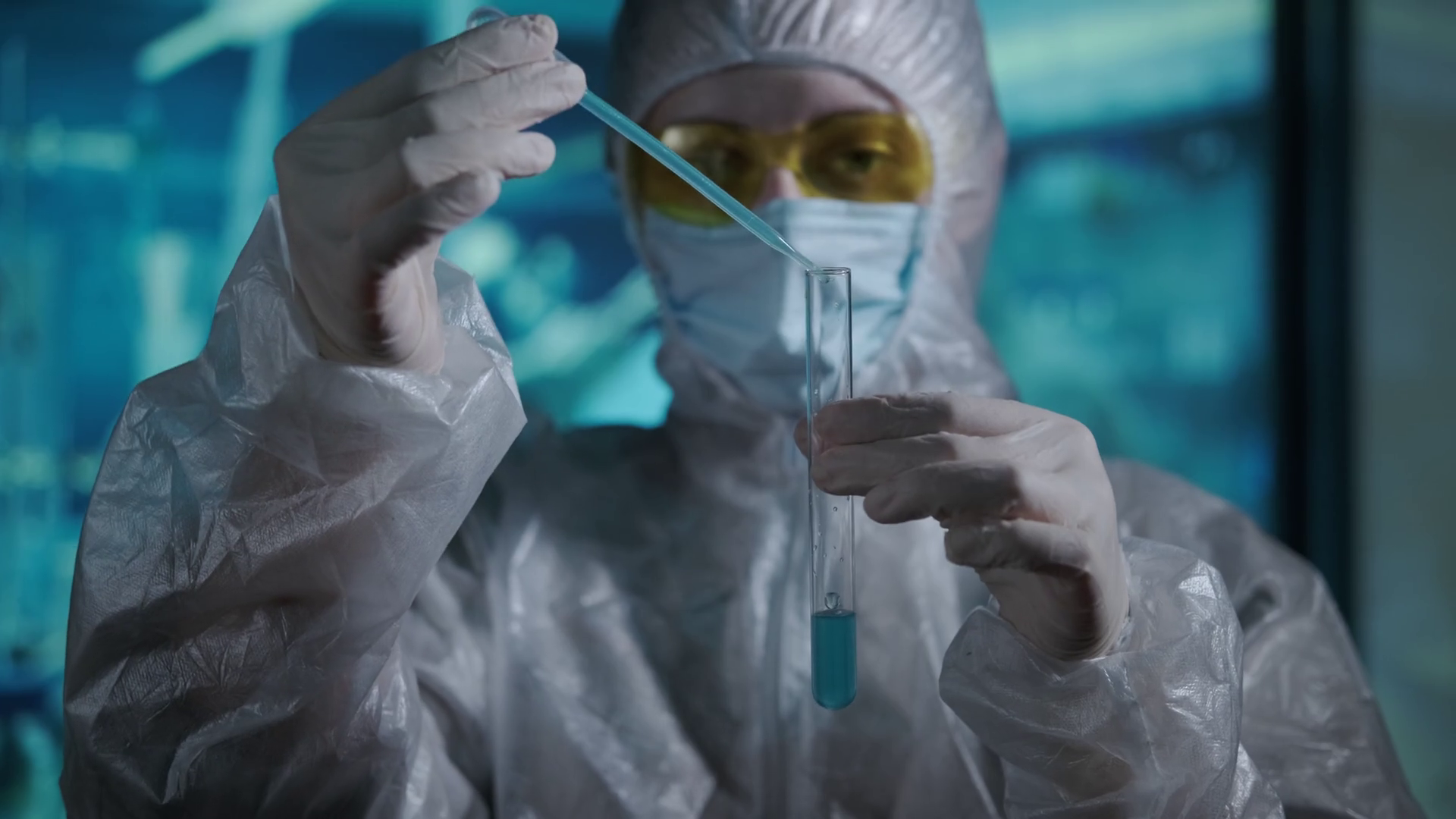 Researcher in a protective suit, mask, goggles and gloves works in a