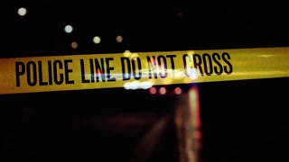 Police line do not cross tape at a crime scene at night with bokeh lights