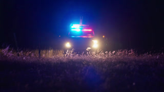 Emergency police car lights approaching in dark night atmosphere
