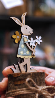 Easter fair. close-up. female hands holding Easter decorations. funny figurine of Easter bunny. traditional european decor for Catholic Easter