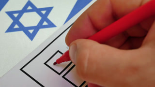 Hand checks box with red marker on ballot. Elections in Israel. National flag in background. Electoral process allows citizens to choose