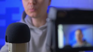 Broadcasting news in home studio. Live streaming by microphone and DSLR camera. Unrecognizable man recording voice podcast. On air channel
