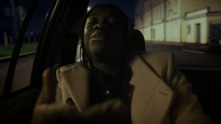 Portrait of self-confident African American rapper in automobile, ride in night . Cool black guy flowing rap, gesticulating and looking at