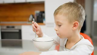 Child enjoying a nutritious breakfast in the kitchen. Nutritious food, balanced meal.