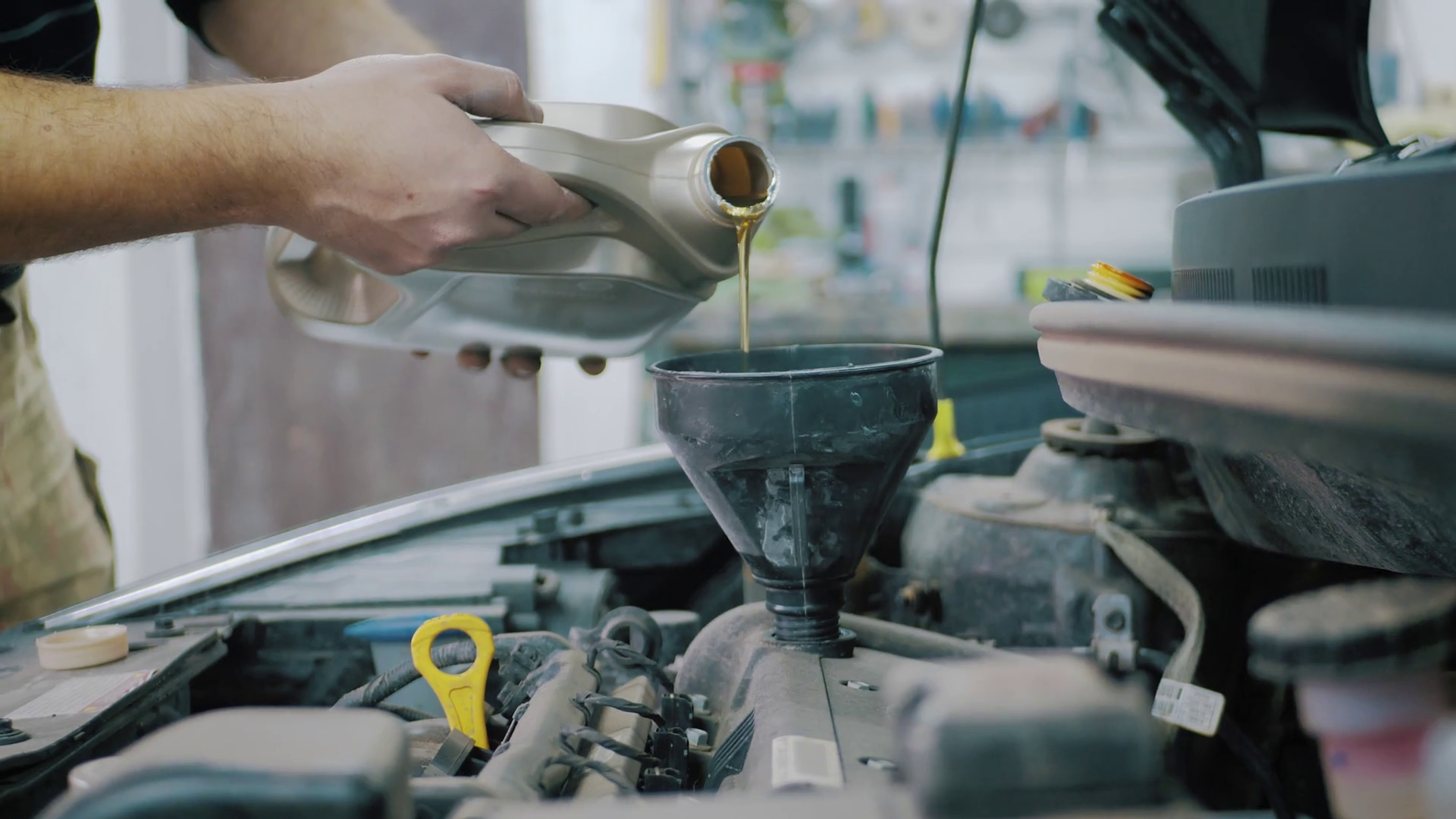 Car maintenance servicing mechanic pouring new oil