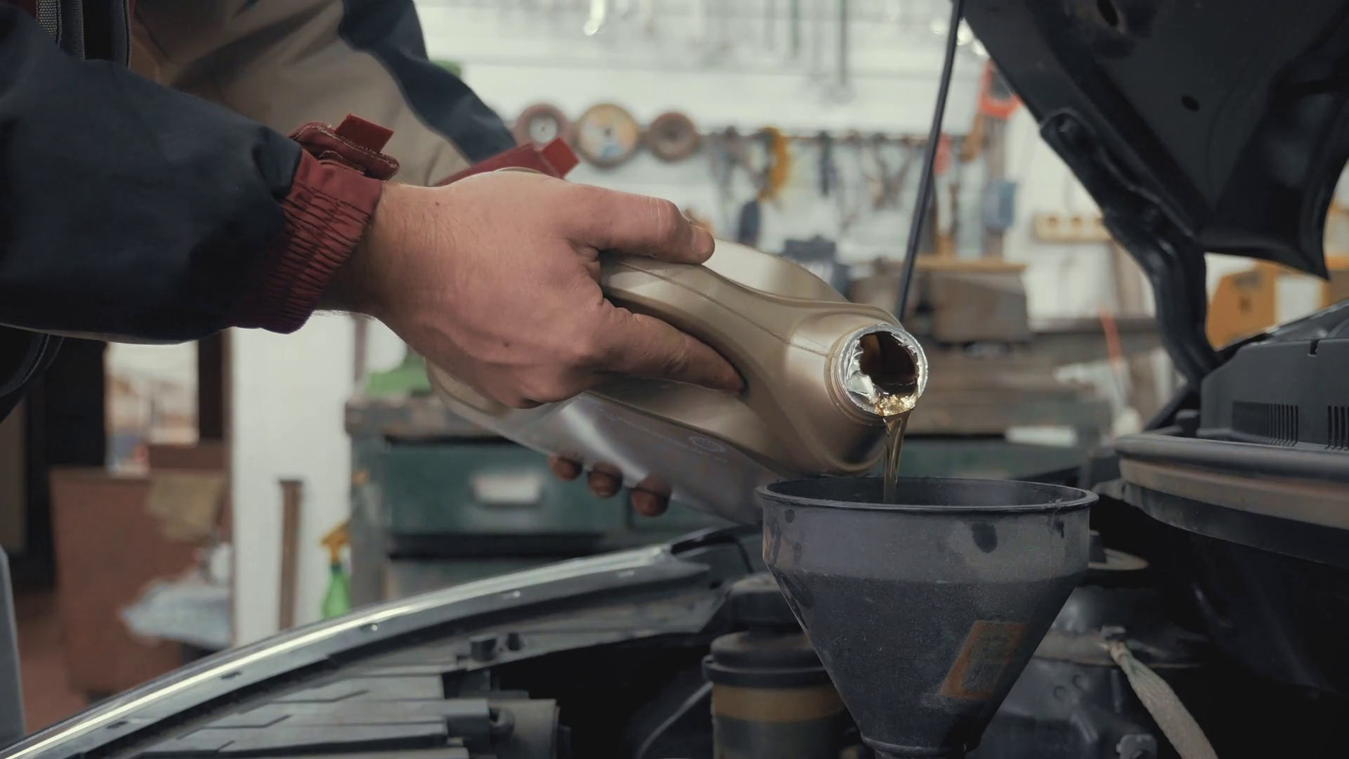 Car maintenance servicing mechanic pouring new oil