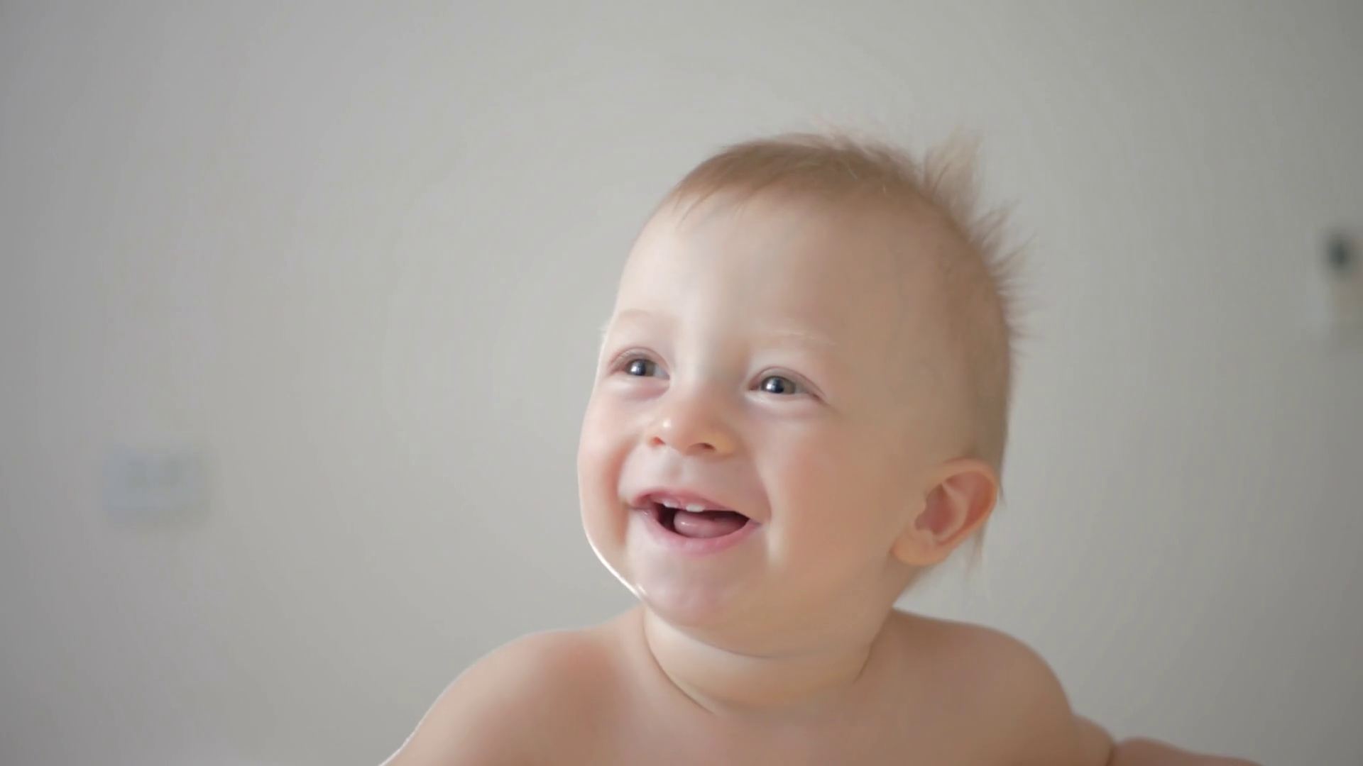 Close up of baby's face while it smiles and laughs. A cute little baby