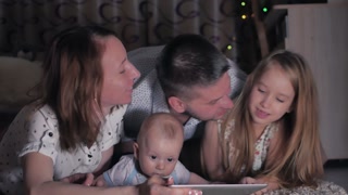 Family bonding with tablet PC at night.