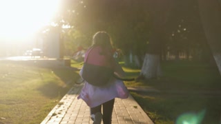 Child with a backpack heading to school. Education concept. Back view, slow motion and steadicam video.