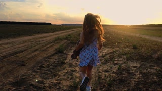 Joyful Child Running in a Green Meadow at Sunset. Smooth Motion. 4K.