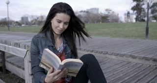 Brunete Woman reading outdoors
